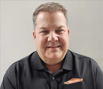 Male employee in front of white wall